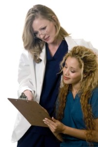 Nurse discussing patient chart with doctor on white